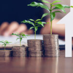 Couples signed a contract to buy a house from the broker. Coin to stack money and model house placed on the table, financial Business Growth.